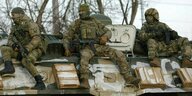 Russische Soldaten sitzen auf einem Panzer