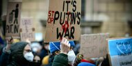 Ein Mann hält ein Plakat mit der Aufschrift "Es ist Putins Krieg" hoch