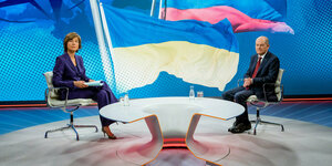 Maybrit Illner und Olaf Scholz sitzen in einem TV-Studio