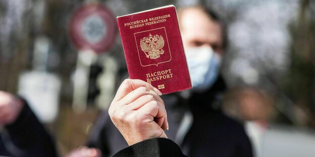 Демонстрант показывает свой паспорт в знак того, что не все россияне поддерживают войну Путина