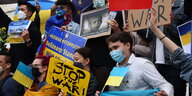 Protestierende mit Schildern in blau-gelb