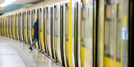 Eine Person steigt in eine gelbe U-Bahn ein.