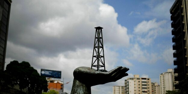 Eine in Caracas stehende Statue hält auf ihrem Handteller einen Ölförderturm.