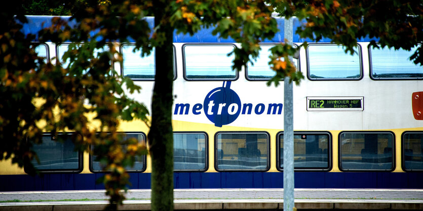 Ein Metronom-Zug schillert zwischen Bäumen hindurch