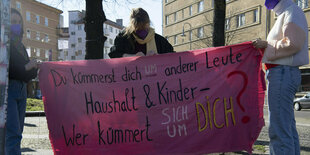 Protestierende halten einen Banner für mehr Anerkennung von Care-Arbeit