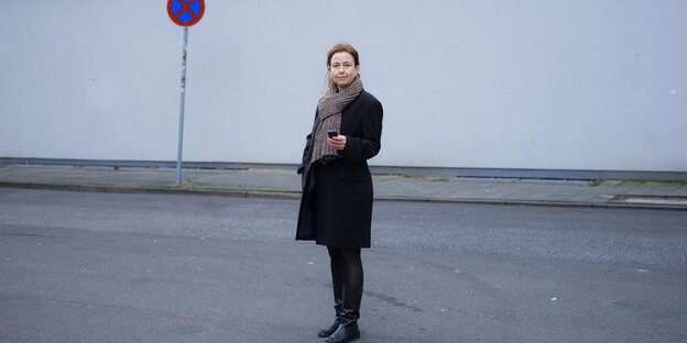 Eine Frau steht auf einer menschenleeren Straße und blickt in die Kamera: „Heimat finde ich einen schwierigen Begriff“, sagt die Autorin Dagrun Hintze, hier spazierend in Hamburg-Altona