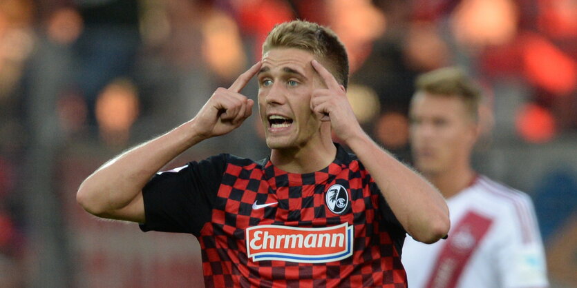 Nils Petersen tippt sich mit beiden Zeigefingern an den Kopf