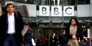 Menschen vor dem Gebäude der BBC in London mit großem Schriftzug