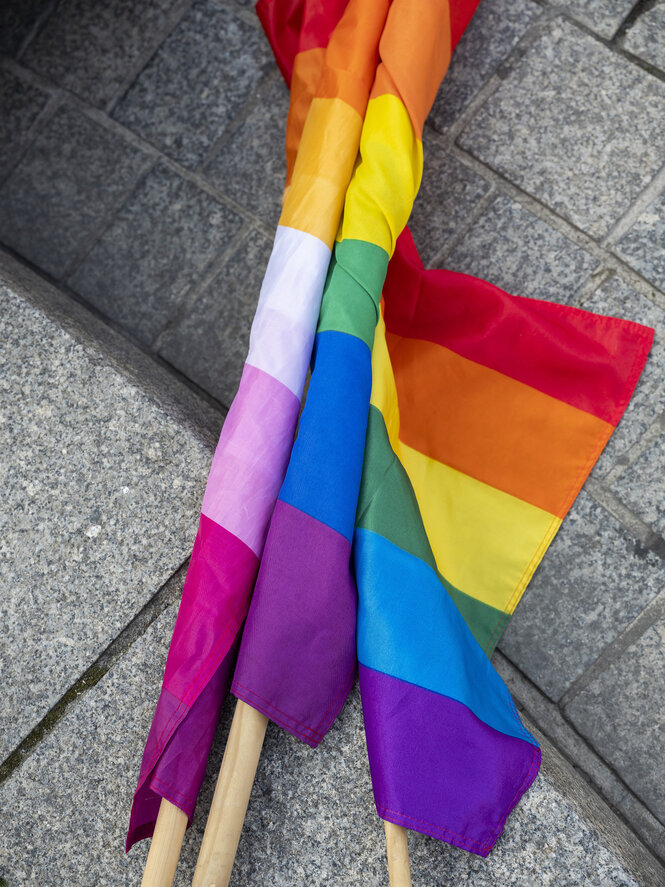 Zusammengerollte bunte Fahnen liegen auf dem Boden