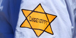 Auf einem Hemd ist ein Gelber Stern angeneht mit der Aufschrift "Ungeimpft"