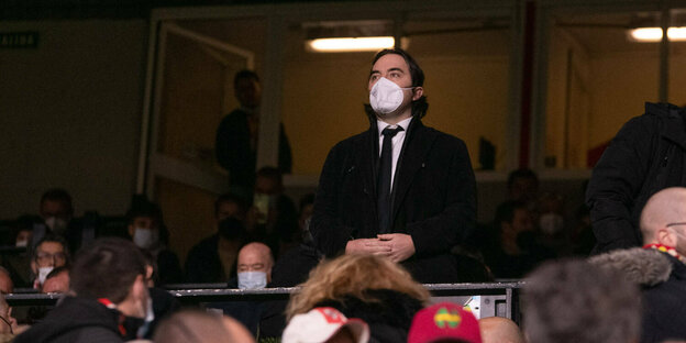 Raúl Martín Presa steht mit Maske auf der Ehrentribüne im Stadion