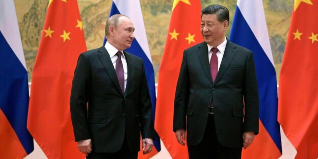 Wladimir Putin mit Chinas Staatschef Xi Jinping stehen vor den Flaggen Russlands und China