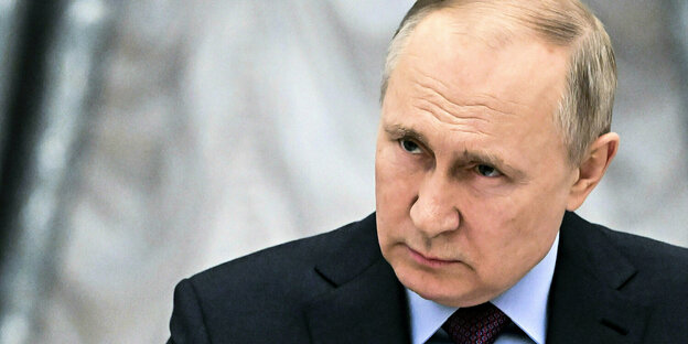 Vladimir Putin looks to the side seriously