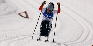 Die paralympische Sportlerin Yang Hongqiong aus China beim Skilanglauf im Sitzen
