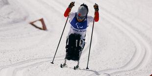 Die paralympische Sportlerin Yang Hongqiong aus China beim Skilanglauf im Sitzen