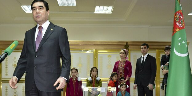 Der Diktator am Mikrofon mit der Familie seines Sohnes im Hintergrund.