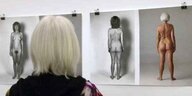 Eine Frau blickt auf Fotografien mit weiblichen nackten Körpern.