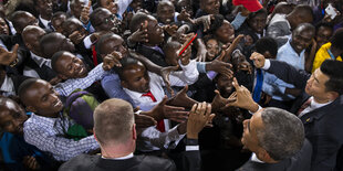 Barack Obama in einer Menschenmasse, die ihm die Hände entgegenstrecken