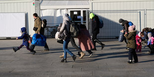 Kriegsflüchtlinge aus der Ukraine gehen am Hauptbahnhof Berlin zum Zelt der Berliner Stadtmission, das als Erstanlaufstelle für Geflüchtete dient