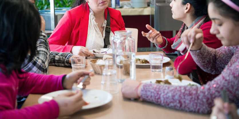 Schülerinnen sitzen am Tisch und essen