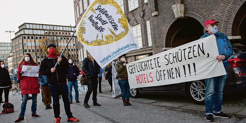 Mehrere Menschen mit Transparent stehen vor der Hamburger Finanzbehörde