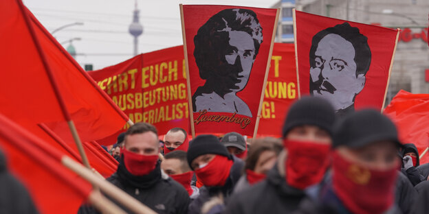 Rote Fahnen mit den Gesichtern Rosa Luxemburgs und Karl Liebknechts bei der jährlichen Demo zu ihrem Todestag in Berlin.