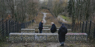 Zwei Vertreter des Bezirksamtes von Friedrichshain-Kruezberg und der Autor des Testes stehen am Rande des Kleinen Bunkerberges im Volkspark Friedrichshain und begutachten den Verlauf der Umgestaltungsmaßnahmen im Park