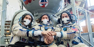 Drei Astronauten in ihren Weltraum-Anzügen