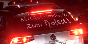 Ein Teilnehmer eines Autokorsos "gegen die erhöhten Spritpreise" hat auf die Heckscheibe seines Fahrzeugs die Worte "Mit dem letzten Tropfen zum Protest" geschrieben.