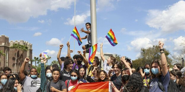 Eine Gruppe junger Leute mit Regenbogenfahnen