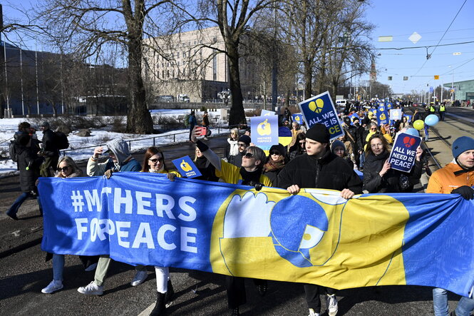 Frauen mit einer Protestfahne #Mothers for Peace in den Farben der Ukraine gelb-blau