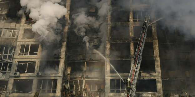 Feuerwehrleute versuchen, einen Brand in einem zerstörten Wohnhaus