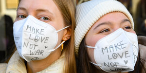 2 Frauen mit Beschrifteten Masken: Male Love not War