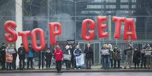 Demonstranten halten Buchstaben Hoch: STOP CETA
