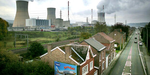 Im Vordergrund eine Hauptverkehrsstraße, die durch eine belgische Siedlung führt. Im Hintergrund: die Meiler des Atomkraftwerks Tihange