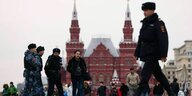 Polizisten und Militär in Winterkleidung vor einer roten Kirche - Roter Platz in Moskau
