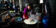 Chinesin bereitet auf einem Markt ein Jianbing zu