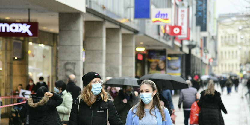 Menschen auf einer Einkaufstrasse mit Einkaufstaschen