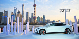 Ein PKW wird vor eider Skyline Schanghais präsentiert.