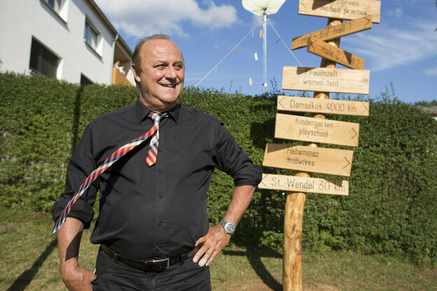 Klaus Bouillon vor einem aufgestellten Wegweiser aus Holz Klaus Bouillon vor einem aufgestellten Wegweiser aus Holz