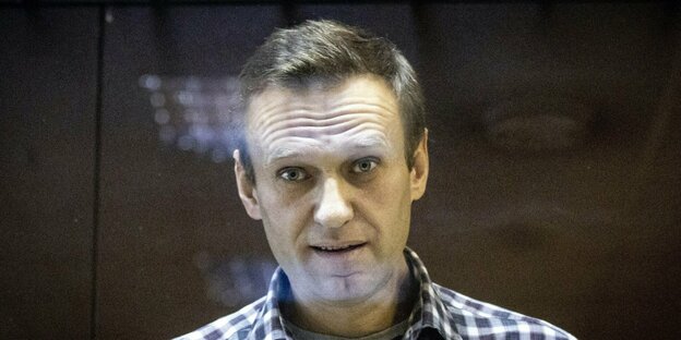 Alexej Nawalny runzelt hinter einer Glasscheibe die Stirn