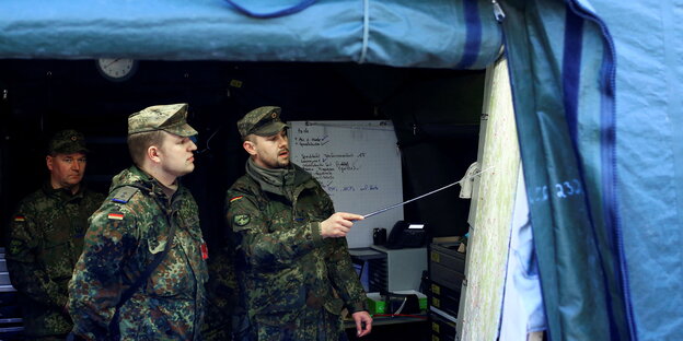 Drei Bundeswehrsoldaten vor einem Zelt