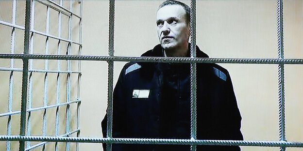 Oppositionspolitiker Nawalny auf einem Videobild hinter Gitter.