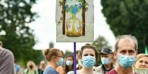 Menschen mit Mundschutzmasken demonstrieren