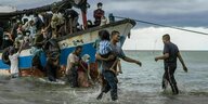 Fischer helfen Rohingya-Migranten beim Aussteigen aus einem Boot