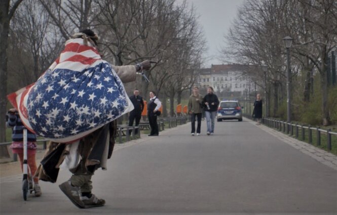 Der Görlitzerpark in Berlin. Mehrere Personen und ein Polizeiauto zwischen Bäumen