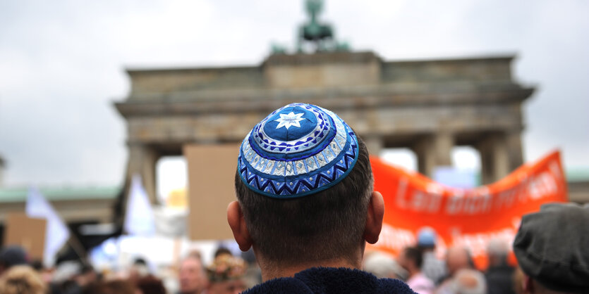 ein Mann mit Kippa steht vor dem Brandenburger Tor