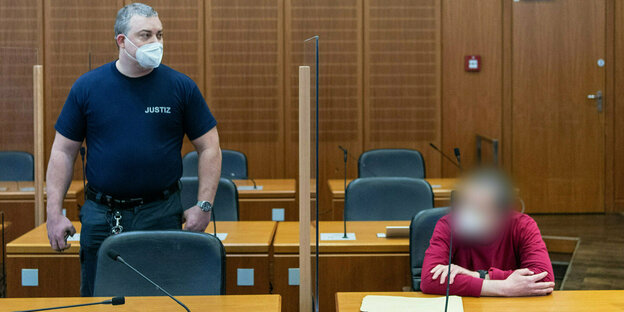 Ein verpixelter Mann sitzt auf der Anklagebank im Gerichtssaal