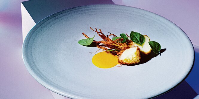 Ein weißer Teller mit Majoran und Sellerie im Restaurant NObelhart & Schmutzig