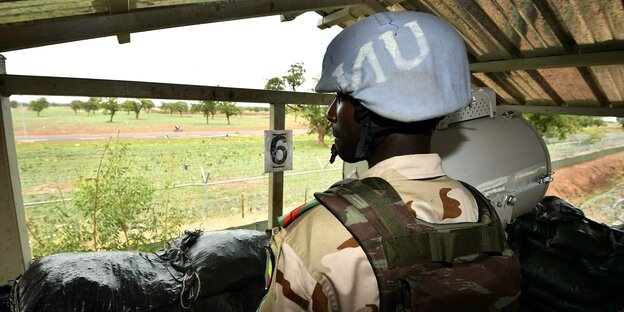Ein Soldat trägt einen blauen Helm mit der Aufschrift UN
